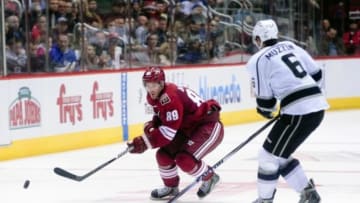 Dec 4, 2014; Glendale, AZ, USA; Arizona Coyotes left wing Mikkel Boedker (89) carries the puck as Los Angeles Kings defenseman Jake Muzzin (6) defends during the third period at Gila River Arena. Mandatory Credit: Matt Kartozian-USA TODAY Sports