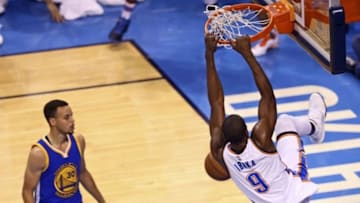 May 22, 2016; Oklahoma City, OK, USA; Oklahoma City Thunder forward Serge Ibaka (9) dunks past Golden State Warriors guard Stephen Curry (30) during the first quarter in game three of the Western conference finals of the NBA Playoffs at Chesapeake Energy Arena. Mandatory Credit: Kevin Jairaj-USA TODAY Sports
