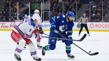 VANCOUVER, CANADA - FEBRUARY 15: Phillip Di Giuseppe #34 of the Vancouver Canucks skates with the puck as Jacob Trouba #8 of the New York Rangers defends during the second period of their NHL game at Rogers Arena on February 15, 2023 in Vancouver, British Columbia, Canada. (Photo by Derek Cain/Getty Images)