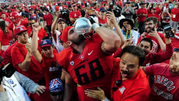 Nov 28, 2014; Tucson, AZ, USA; Arizona Wildcats offensive lineman Mickey Baucus (68) hoists the territorial cup in celebration after beating the Arizona State Sun Devils 42-35 at Arizona Stadium. Mandatory Credit: Matt Kartozian-USA TODAY Sports