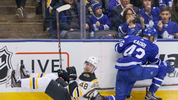 TORONTO, ON - FEBRUARY 24: Boston Bruins defenseman Matt Grzelcyk (48) and Toronto Maple Leafs center Nazem Kadri (43) collide along the side boards. Toronto Maple Leafs VS New Jersey Devils during 3rd period action in NHL regular season play at the Air Canada Centre. Leafs won 4-3 on a Ron Hainsey goal late in the game. Toronto Star/Rick Madonik (Rick Madonik/Toronto Star via Getty Images)