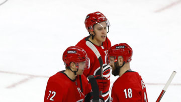 RALEIGH, NORTH CAROLINA - DECEMBER 16: Jack Drury #72 of the Carolina Hurricanes is presented the game puck by his teammate Derek Stepan #18 following the game against the Detroit Red Wings at PNC Arena on December 16, 2021 in Raleigh, North Carolina. (Photo by Jared C. Tilton/Getty Images)