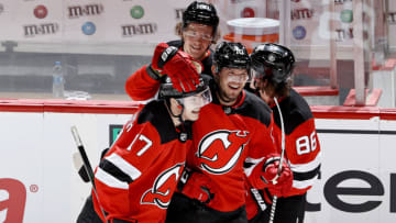 NEWARK, NEW JERSEY - JANUARY 16: Egor Sharangovich #17 of the New Jersey Devils is congratulated by teammates Dmitry Kulikov #70, Jack Hughes #86 and Jesper Boqvist #90 after he scored the game winning goal in overtime against the Boston Bruins at Prudential Center on January 16, 2021 in Newark, New Jersey. Due to Covid-19 restrictions, the game is played without fans. The New Jersey Devils defeated the Boston Bruins 2-1. This was the first career NHL goal for Egor Sharangovich of the Devils. (Photo by Elsa/Getty Images)