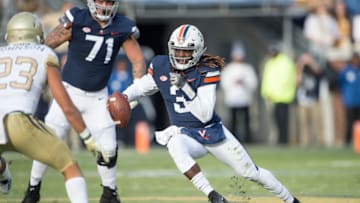 ATLANTA, GA - NOVEMBER 17: Quarterback Bryce Perkins #3 of the Virginia Cavaliers looks to maneuver by defensive back Jalen Johnson #23 of the Georgia Tech Yellow Jackets during the first quarter at Bobby Dodd Stadium on November 17, 2018 in Atlanta, Georgia. (Photo by Michael Chang/Getty Images)