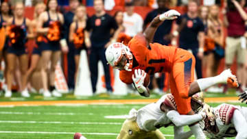 SYRACUSE, NY - SEPTEMBER 15: Moe Neal #21 of the Syracuse Orange is tripped up by Florida State Seminoles players during the first half at the Carrier Dome on September 15, 2018 in Syracuse, New York. (Photo by Brett Carlsen/Getty Images)