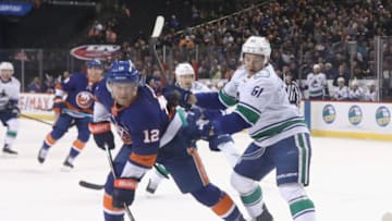 NEW YORK, NEW YORK - FEBRUARY 01: Troy Stecher #51 of the Vancouver Canucks checks Josh Bailey #12 of the New York Islanders at the Barclays Center on February 01, 2020 in the Brooklyn borough of New York City. (Photo by Bruce Bennett/Getty Images)