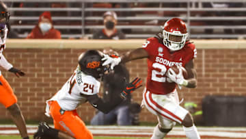 Nov 21, 2020; Norman, Oklahoma, USA; Oklahoma Sooners running back Rhamondre Stevenson (29) stiff arms Oklahoma State Cowboys cornerback Jarrick Bernard-Converse (24) during the first half at Gaylord Family-Oklahoma Memorial Stadium. Mandatory Credit: Kevin Jairaj-USA TODAY Sports