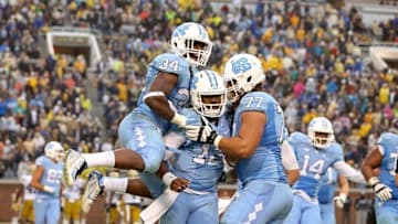 Oct 3, 2015; Atlanta, GA, USA; North Carolina Tar Heels quarterback Marquise Williams (12, center) celebrates with running back Elijah Hood (34) and offensive tackle John Ferranto (77) after Williams