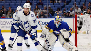 Oct 17, 2023; Buffalo, New York, USA; Tampa Bay Lightning left wing Brandon Hagel (38) and Buffalo Sabres goaltender Devon Levi (27) look for the puck during the first period at KeyBank Center. Mandatory Credit: Timothy T. Ludwig-USA TODAY Sports