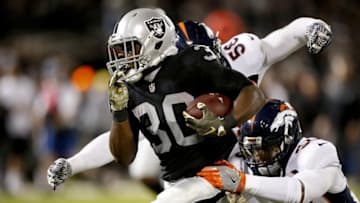 Nov 6, 2016; Oakland, CA, USA; Oakland Raiders running back Jalen Richard (30) runs for a first down before being tackled by Denver Broncos outside linebacker Shane Roy (56) in the second quarter at Oakland Coliseum. Mandatory Credit: Cary Edmondson-USA TODAY Sports