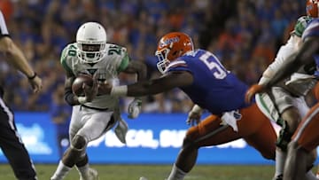 Sep 17, 2016; Gainesville, FL, USA; North Texas Mean Green running back Jeffrey Wilson (26) runs with the ball as Florida Gators defensive lineman Caleb Brantley (57) defends during the second half at Ben Hill Griffin Stadium. Florida Gators defeated the North Texas Mean Green 32-0. Mandatory Credit: Kim Klement-USA TODAY Sports