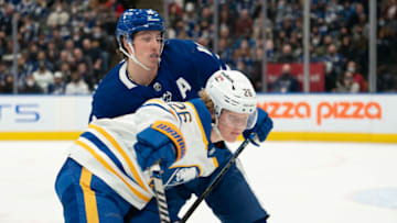 Mar 2, 2022; Toronto, Ontario, CAN; Toronto Maple Leafs right wing Mitchell Marner (16) battles with Buffalo Sabres defenseman Rasmus Dahlin (26) during the first period at Scotiabank Arena. Mandatory Credit: Nick Turchiaro-USA TODAY Sports