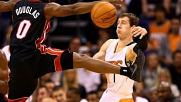 Feb 11, 2014; Phoenix, AZ, USA; Phoenix Suns guard Goran Dragic (right) passes the ball under pressure from Miami Heat guard Toney Douglas in the first quarter at the US Airways Center. Mandatory Credit: Mark J. Rebilas-USA TODAY Sports