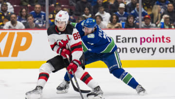Mar 15, 2022; Vancouver, British Columbia, CAN; Vancouver Canucks forward Tanner Pearson (70) stick checks New Jersey Devils forward Jack Hughes (86) in the second period at Rogers Arena. Mandatory Credit: Bob Frid-USA TODAY Sports