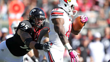 Derek Wolfe of the Cincinnati Bearcats tackles Dominique Brown of the Louisville Cardinals during game at Paul Brown Stadium. Getty Images.