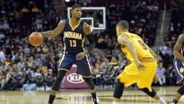 Oct 15, 2015; Cleveland, OH, USA; Indiana Pacers forward Paul George (13) dribbles against Cleveland Cavaliers guard Jared Cunningham (9) in the third quarter at Quicken Loans Arena. Mandatory Credit: David Richard-USA TODAY Sports