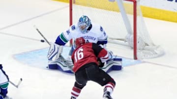 Feb 10, 2016; Glendale, AZ, USA; Vancouver Canucks goalie Ryan Miller (30) makes a save on Arizona Coyotes center Max Domi (16) during the first period at Gila River Arena. Mandatory Credit: Matt Kartozian-USA TODAY Sports