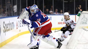NEW YORK, NEW YORK - DECEMBER 04: Alexandar Georgiev #40 of the New York Rangers clears the puck as Alex DeBrincat #12 of the Chicago Blackhawks closes in during the first period at Madison Square Garden on December 04, 2021 in New York City. (Photo by Elsa/Getty Images)