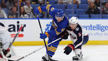 Sep 30, 2023; Buffalo, New York, USA; Buffalo Sabres defenseman Riley Stillman (61) takes a shot on goal as Columbus Blue Jackets defenseman Denton Mateychuk (5) tries to defend during the second period at KeyBank Center. Mandatory Credit: Timothy T. Ludwig-USA TODAY Sports