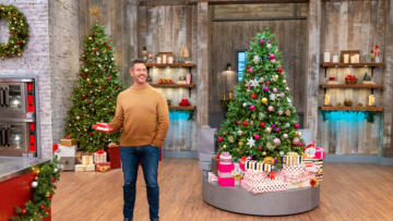 Host Jesse Palmer presents the wrapping paper cakes challenge, as seen on Holiday Baking Championship, Season 10.