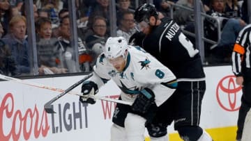 Apr 14, 2016; Los Angeles, CA, USA; Los Angeles Kings defenseman Jake Muzzin (6) and San Jose Sharks center Joe Pavelski (8) battle for the puck along the boards in the third period of the game one of the first round of the 2016 Stanley Cup Playoffs at Staples Center. Sharks won 4-3. Mandatory Credit: Jayne Kamin-Oncea-USA TODAY Sports