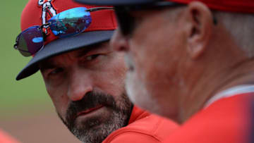 Mar 10, 2020; Peoria, Arizona, USA; Los Angeles Angels pitching coach Mickey Callaway (left) talks with manager Joe Maddon during the second inning of a spring training game against the Seattle Mariners at Peoria Stadium. Mandatory Credit: Joe Camporeale-USA TODAY Sports