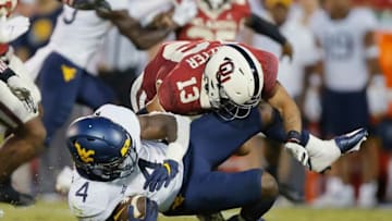 Oklahoma's Shane Whitter (13) brings down West Virginia's Leddie Brown (4) during a college football game between the University of Oklahoma Sooners (OU) and the West Virginia Mountaineers at Gaylord Family-Oklahoma Memorial Stadium in Norman, Okla., Saturday, Sept. 25, 2021. Oklahoma won 16-13.Lx11223