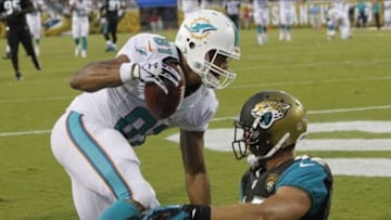 Aug 9, 2013; Jacksonville, FL, USA;Miami Dolphins tight end Dustin Keller (81) catches the ball for a touchdown as Jacksonville Jaguars free safety Chris Prosinski (42) attempted to defend during the first quarter at EverBank Field. Mandatory Credit: Kim Klement-USA TODAY Sports