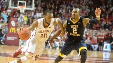 Jan 16, 2016; Norman, OK, USA; Oklahoma Sooners guard Jordan Woodard (10) drives to the basket in front of West Virginia Mountaineers guard Jevon Carter (2) during the second half at Lloyd Noble Center. Mandatory Credit: Mark D. Smith-USA TODAY Sports