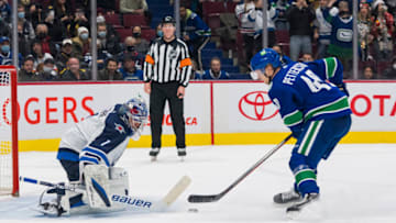 Dec 10, 2021; Vancouver, British Columbia, CAN; Vancouver Canucks forward Elias Pettersson (40) scores on Winnipeg Jets goalie Eric Comrie (1) during the shootout in the overtime period at Rogers Arena. Vancouver wins 4-3 in a shootout. Mandatory Credit: Bob Frid-USA TODAY Sports