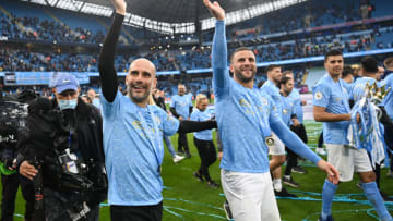 MANCHESTER, ENGLAND - MAY 23: Pep Guardiola, Manager of Manchester City and Kyle Walker of Manchester City show appreciation to the fans as Manchester City are presented with the Trophy as they win the league following the Premier League match between Manchester City and Everton at Etihad Stadium on May 23, 2021 in Manchester, England. A limited number of fans will be allowed into Premier League stadiums as Coronavirus restrictions begin to ease in the UK. (Photo by Michael Regan/Getty Images)