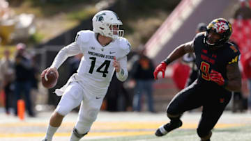 COLLEGE PARK, MD - NOVEMBER 03: Brian Lewerke #14 of the Michigan State Spartans runs past Byron Cowart #9 of the Maryland Terrapins during the first half at Capital One Field on November 3, 2018 in College Park, Maryland. (Photo by Will Newton/Getty Images)