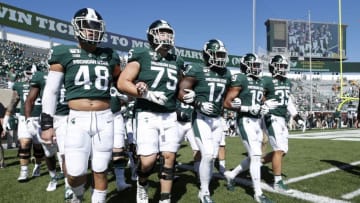 EAST LANSING, MI - SEPTEMBER 14: Michigan State Spartans players walk around the field with locked arms prior to the game against the Arizona State Sun Devils at Spartan Stadium on September 14, 2019 in East Lansing, Michigan. (Photo by Joe Robbins/Getty Images)