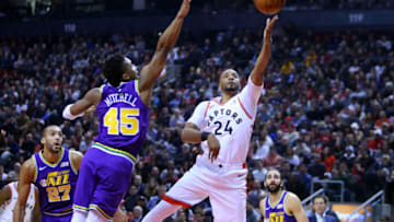 TORONTO, ON - JANUARY 1: Norman Powell #24 of the Toronto Raptors shoots the ball as Donovan Mitchell #45 of the Utah Jazz defends during the first half of an NBA game at Scotiabank Arena on January 1, 2019 in Toronto, Canada. NOTE TO USER: User expressly acknowledges and agrees that, by downloading and or using this photograph, User is consenting to the terms and conditions of the Getty Images License Agreement. (Photo by Vaughn Ridley/Getty Images)