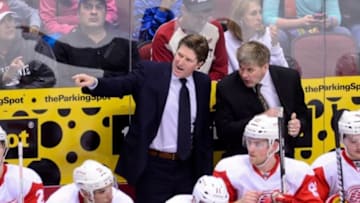 Apr. 4, 2013; Glendale, AZ, USA; Detroit Red Wings head coach Mike Babcock (left) talks with assistant coach Bill Peters (right) during the first period against the Phoenix Coyotes at Jobing.com Arena. Mandatory Credit: Matt Kartozian-USA TODAY Sports