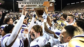 Nov 26, 2022; Pullman, Washington, USA; Washington Huskies players carry the Apple Cup Trophy after defeating the Washington State Cougars at Gesa Field at Martin Stadiu. Washington won 51-33. Mandatory Credit: James Snook-USA TODAY Sports