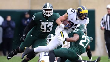 EAST LANSING, MI - OCTOBER 20: Zach Gentry #83 of the Michigan Wolverines battles for yards between Naquan Jones #93 and Khari Willis #27 of the Michigan State Spartans at Spartan Stadium on October 20, 2018 in East Lansing, Michigan. Michigan won the game 21-7. (Photo by Gregory Shamus/Getty Images)