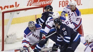 WINNIPEG, MB - DECEMBER 18: Henrik Lundqvist #30 of the New York Rangers keeps his eyes on the puck as is goes behind Jacob Trouba #8 of the Winnipeg Jets in first period action in an NHL game at the MTS Centre on December 18, 2015 in Winnipeg, Manitoba, Canada. (Photo by Marianne Helm/Getty Images)