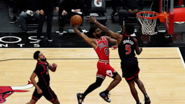 May 13, 2021; Chicago, Illinois, USA; Chicago Bulls guard Coby White (0) goes to the basket while defended by Toronto Raptors forward Stanley Johnson (5) Mandatory Credit: David Banks-USA TODAY Sports