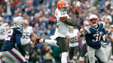 Dec 8, 2013; Foxborough, MA, USA; Cleveland Browns wide receiver Josh Gordon (12) makes a reception as New England Patriots safety Devin McCourty (32) and cornerback Aqib Talib (31) defend on the play during the second quarter at Gillette Stadium. Mandatory Credit: Stew Milne-USA TODAY Sports