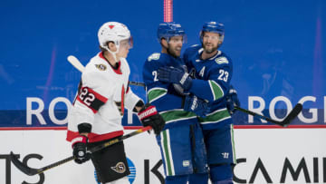 Jan 25, 2021; Vancouver, British Columbia, CAN; Ottawa Senators defenseman Nikita Zaitsev (22) skates by as Vancouver Canucks forward Brandon Sutter (20) and defenseman Alexander Edler (23) celebrate SutterÕs third goal of the game against the Ottawa Senators in the third period at Rogers Arena. Vancouver won 7-1. Mandatory Credit: Bob Frid-USA TODAY Sports