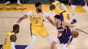 LOS ANGELES, CALIFORNIA - JUNE 03: Devin Booker #1 of the Phoenix Suns dribbles in front of Anthony Davis #3 and LeBron James #23 of the Los Angeles Lakers in the first quarter during game six of the Western Conference first round series at Staples Center on June 03, 2021 in Los Angeles, California. (Photo by Harry How/Getty Images) NOTE TO USER: User expressly acknowledges and agrees that, by downloading and or using this photograph, User is consenting to the terms and conditions of the Getty Images License Agreement.