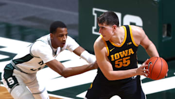EAST LANSING, MICHIGAN - FEBRUARY 13: Luka Garza #55 of the Iowa Hawkeyes handles the ball under pressure from Marcus Bingham Jr. #30 of the Michigan State Spartans at Breslin Center on February 13, 2021 in East Lansing, Michigan. (Photo by Rey Del Rio/Getty Images)