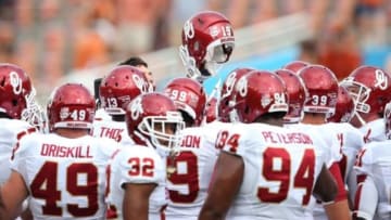 Oct 12, 2013; Dallas, TX, USA; Oklahoma Sooners huddle and raise a helmet prior to the game against the Texas Longhorns during the Red River Rivalry at the Cotton Bowl Stadium. Mandatory Credit: Matthew Emmons-USA TODAY Sports