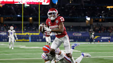 Dec 30, 2020; Arlington, TX, USA; Oklahoma Sooners wide receiver Marvin Mims (17) catches a touchdown pass against Florida Gators defensive back Donovan Stiner (13) in the first quarter at ATT Stadium. Mandatory Credit: Tim Heitman-USA TODAY Sports