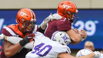 BLACKSBURG, VA - SEPTEMBER 14: Quarterback Ryan Willis #5 of the Virginia Tech Hokies is hit by defensive end Dru Seabrook #40 of the Furman Paladins offensive lineman Christian Darrisaw #77 blocks in the first half at Lane Stadium on September 14, 2019 in Blacksburg, Virginia. (Photo by Michael Shroyer/Getty Images)