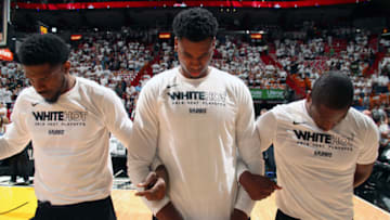 MIAMI, FL - APRIL 21: Udonis Haslem #40, Hassan Whiteside #21, and Dwyane Wade #3 of the Miami Heat stand for the National Anthem before Game Four of the Eastern Conference Quarterfinals against the Philadelphia 76ers during the 2018 NBA Playoffs on April 21, 2018 at American Airlines Arena in Miami, Florida. NOTE TO USER: User expressly acknowledges and agrees that, by downloading and/or using this photograph, user is consenting to the terms and conditions of the Getty Images License Agreement. Mandatory Copyright Notice: Copyright 2018 NBAE (Photo by Issac Baldizon/NBAE via Getty Images)