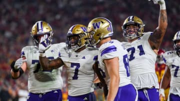 Nov 4, 2023; Los Angeles, California, USA; Washington Huskies running back Dillon Johnson (7), Washington Huskies offensive lineman Nate Kalepo (71) and other teammates celebrate against the USC Trojans during the second quarter at United Airlines Field at Los Angeles Memorial Coliseum. Mandatory Credit: Jonathan Hui-USA TODAY Sports