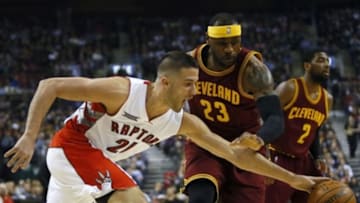 Mar 4, 2015; Toronto, Ontario, CAN; Toronto Raptors guard Greivis Vasquez (21) reaches for a ball as Cleveland Cavaliers forward LeBron James (23) defends during the first half at the Air Canada Centre. Mandatory Credit: John E. Sokolowski-USA TODAY Sports