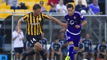 Jun 17, 2015; Charleston, SC, USA; Orlando City midfielder Eric Avila (12) dribbles the ball as Charleston Battery midfielder Jarad van Schwick (14) chases during the first half at Blackbaud Stadium. Orlando City won 8-7 in penalty kicks. Mandatory Credit: Joshua S. Kelly-USA TODAY Sports
